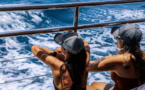 Two people enjoying the view on an Athens Riviera night cruise.