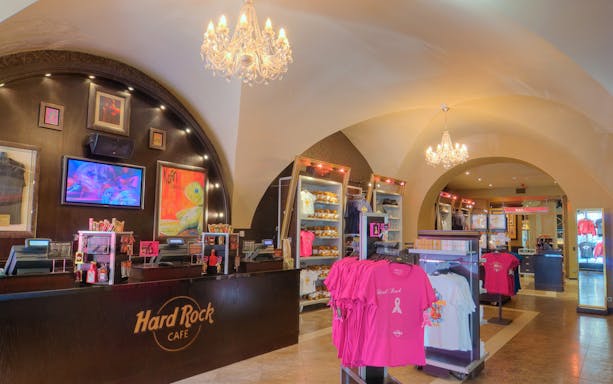 Hard Rock Cafe Prague interior with merchandise displays and chandeliers.