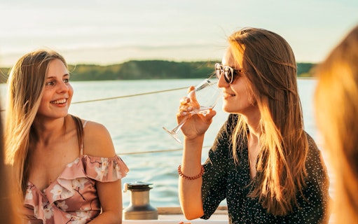 Guests enjoying drinks on a boat during a Luxurious Athens Riviera night party.