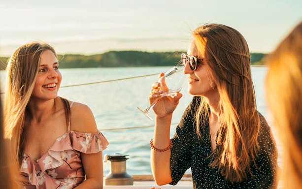 Guests enjoying drinks on a boat during a Luxurious Athens Riviera night party.
