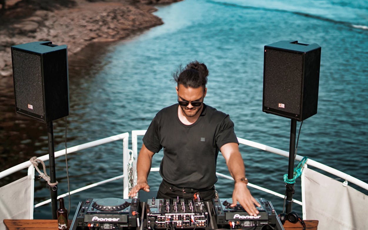 DJ performing on a boat during Athens Riviera night party.