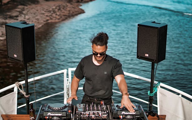 DJ performing on a boat during Athens Riviera night party.
