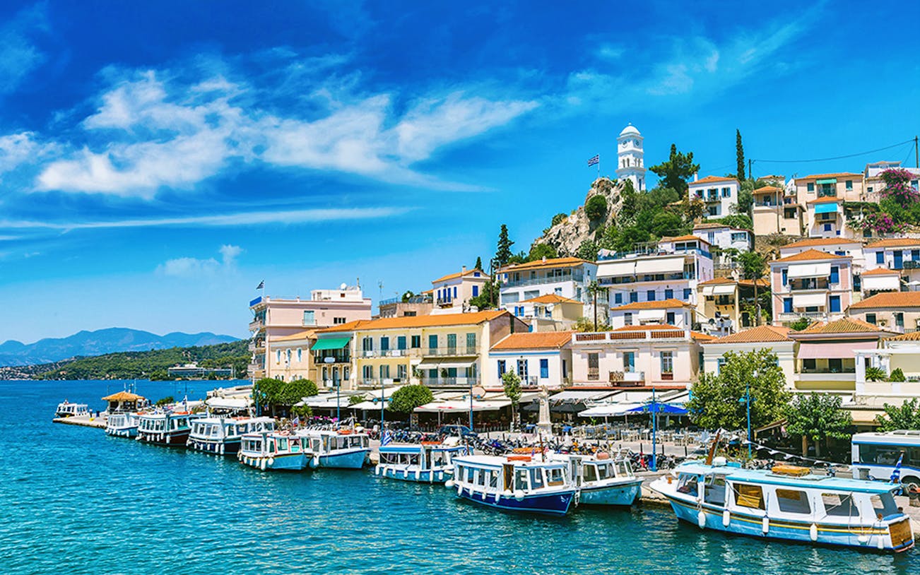 Hydra Island harbor with boats and hillside houses, Greece.