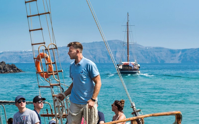 Tourists on a boat during Santorini Volcano Boat Tour with another boat in the background.
