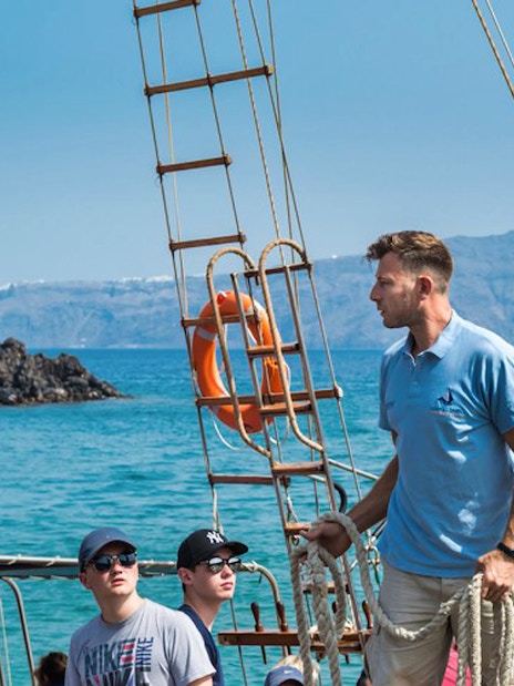 Tourists on a boat during Santorini Volcano Boat Tour with another boat in the background.