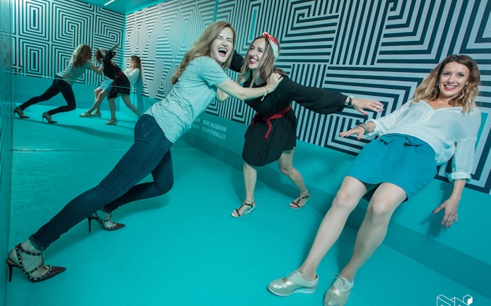 Visitors interacting with optical illusions at Museum of Illusions Vienna.