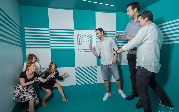 Visitors interacting with exhibits at the Museum of Illusions in Vienna, Austria.