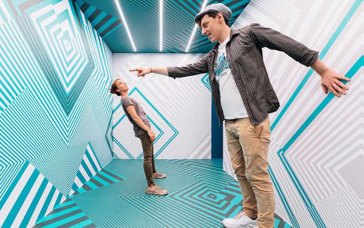 Visitors interacting in an optical illusion room at Museum of Illusions Vienna.