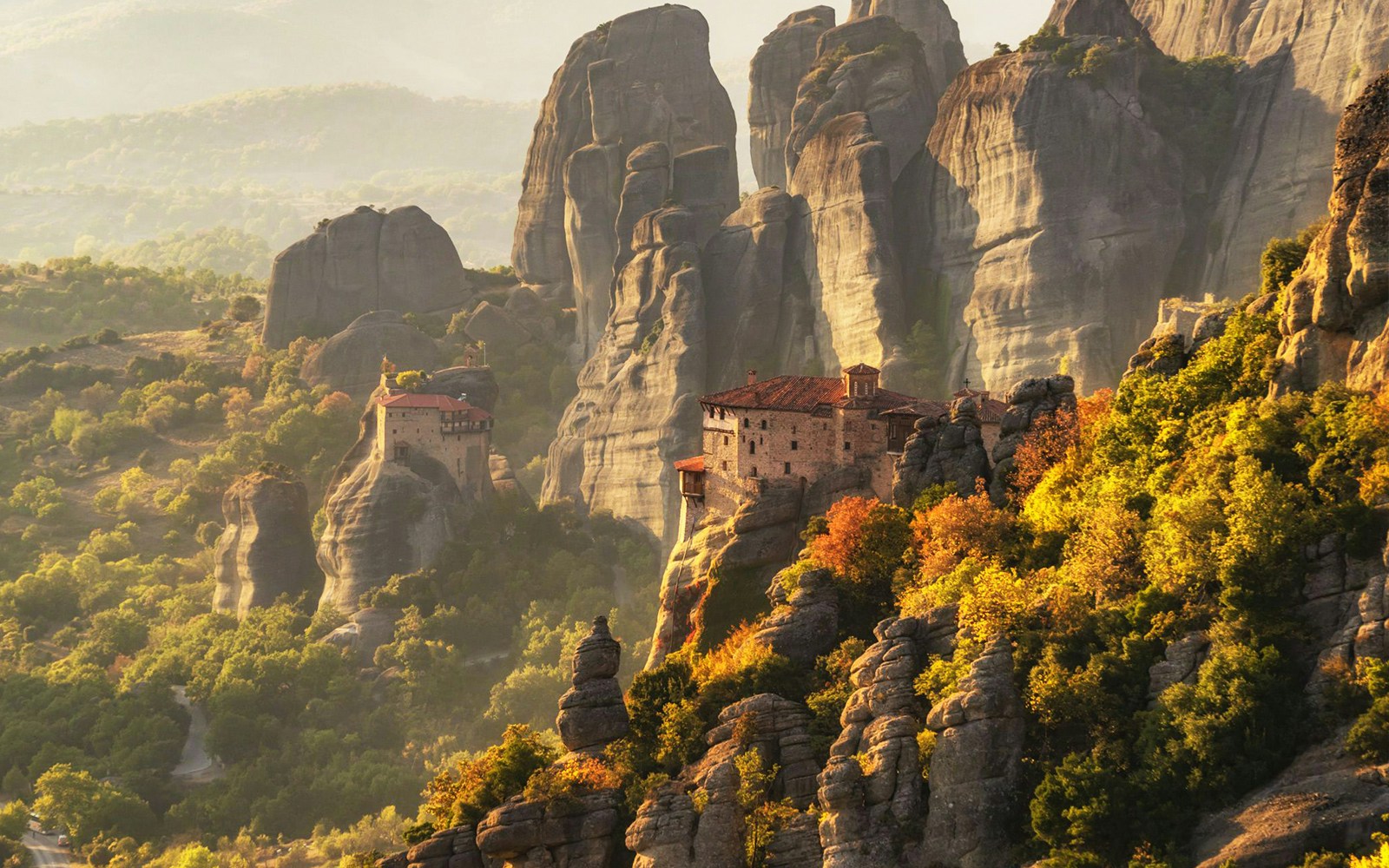 Meteora rock formations at sunrise with monasteries in Greece.