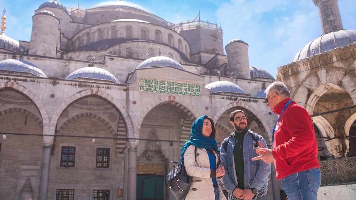 Tour guide with visitors at the Blue Mosque, Istanbul.
