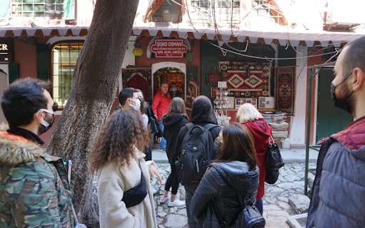 Tour group exploring a carpet shop in Istanbul's Grand Bazaar.