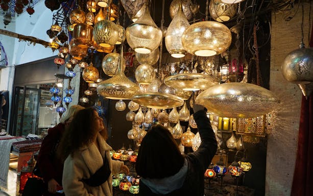 Shoppers admire ornate lamps at Istanbul's Grand Bazaar.