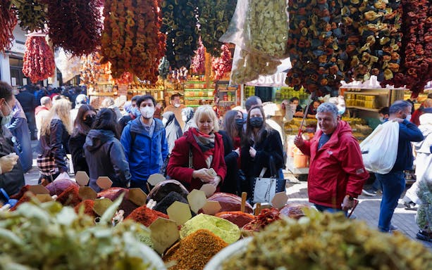Visitors exploring vibrant spice stalls at Istanbul's Grand Bazaar.