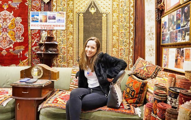 Visitor sitting in a carpet shop at Istanbul's Grand Bazaar.
