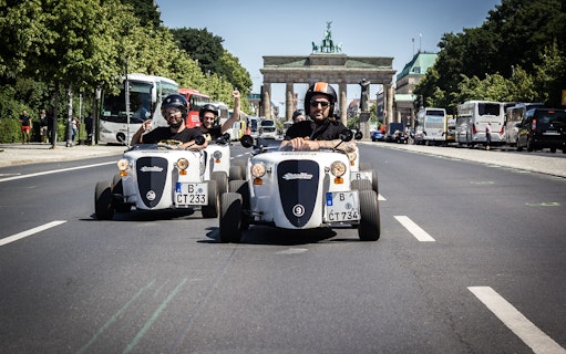 Hot Rod cars driving near Brandenburg Gate in Berlin.