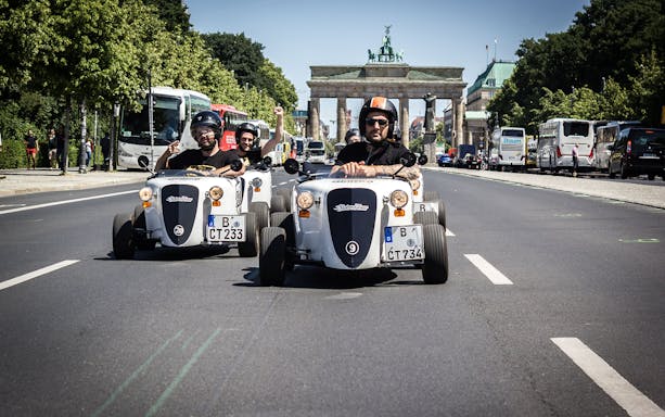 Hot Rod cars driving near Brandenburg Gate in Berlin.