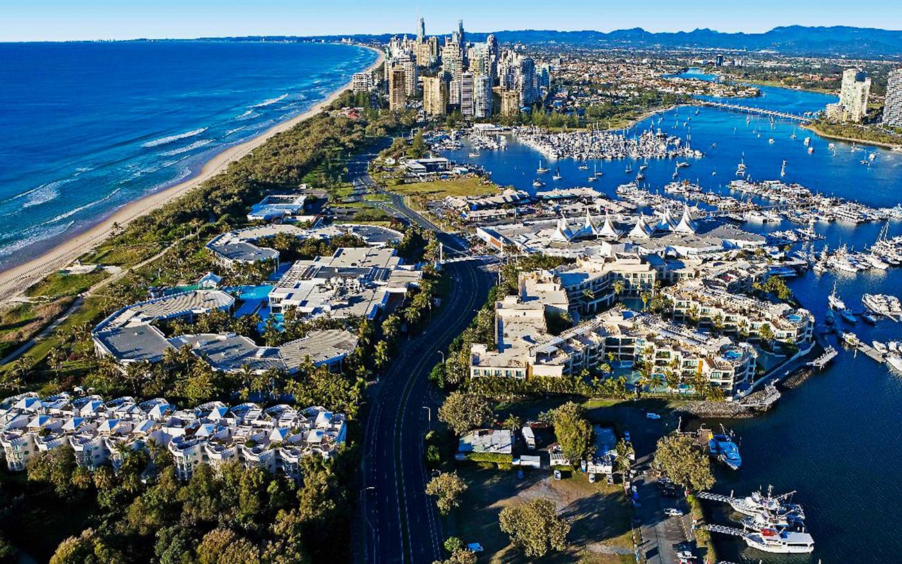 Jetboat speeding on Gold Coast waters with hot air balloon in the sky.