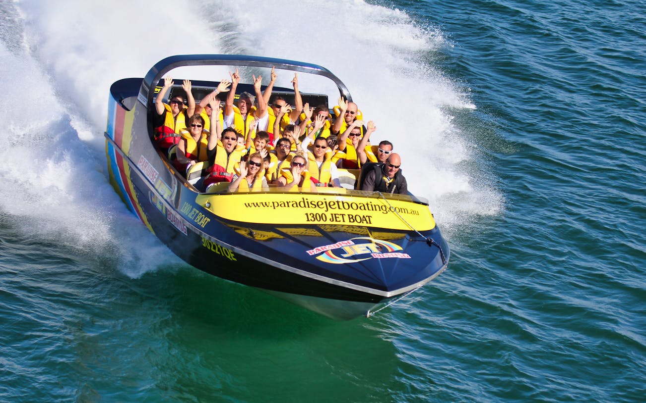 Jet boat with passengers enjoying a ride on the water, part of a Jetboating & Parasailing Combo for 2.