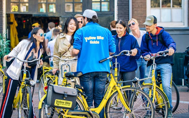 Group on yellow bikes with guide in Amsterdam.