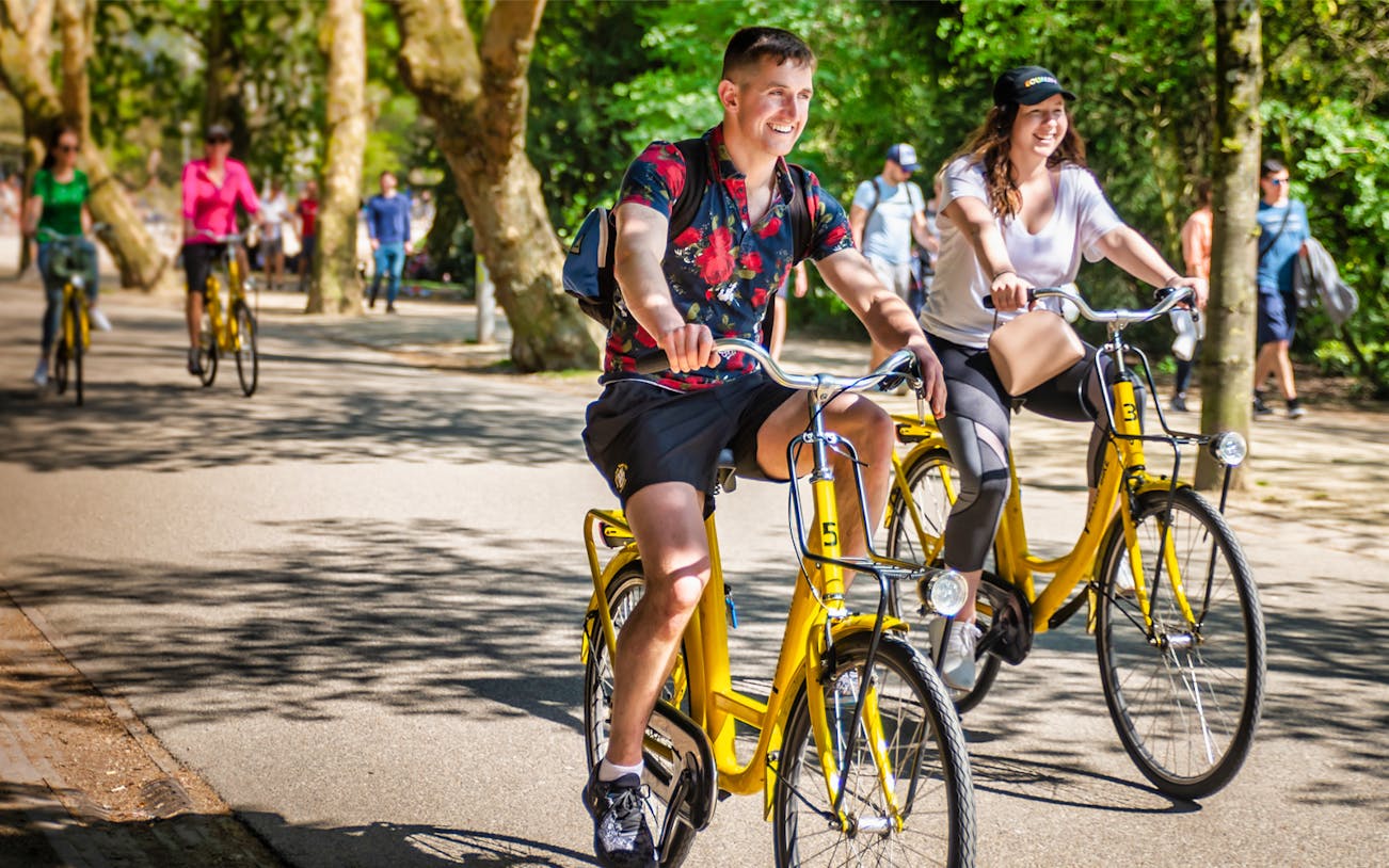Cyclists enjoying a guided bike tour in Amsterdam park.