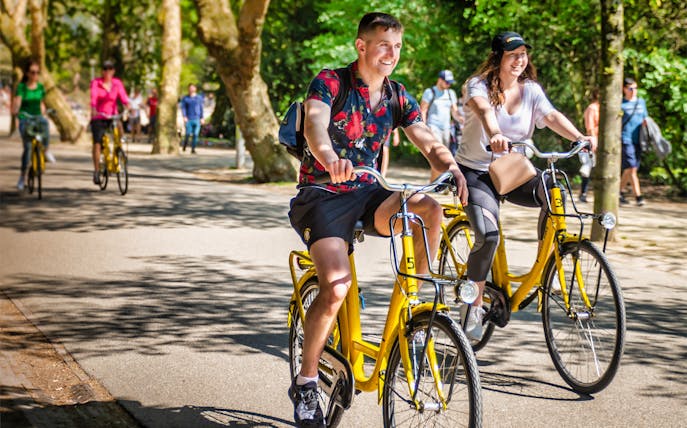 Cyclists enjoying a guided bike tour in Amsterdam park.