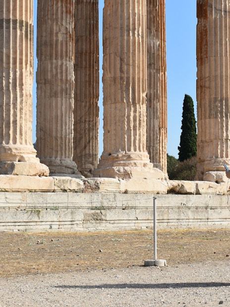 Visitor with audio guide at Temple of Olympian Zeus, Athens.