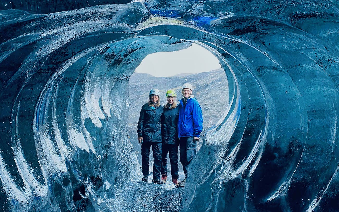 Visitors exploring an ice cave near Katla Volcano on a Reykjavik day tour.