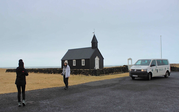 Black church and minibus on Snaefellsnes Peninsula tour, Iceland.