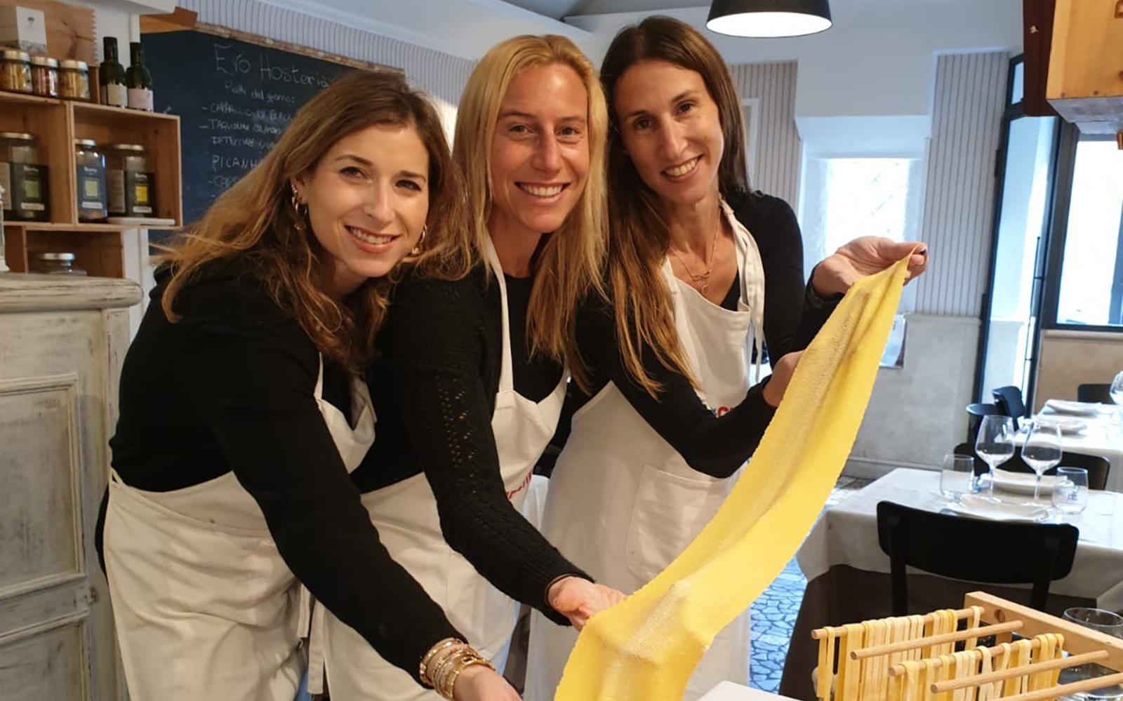 Women making fresh pasta in an Italian cooking class.