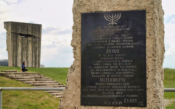 Memorial at Plaszow Concentration Camp site with commemorative plaques and stone structures.