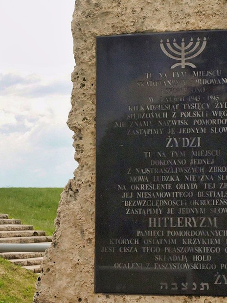 Memorial at Plaszow Concentration Camp site with commemorative plaques and stone structures.