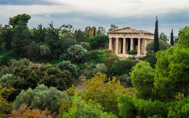 Ancient Agora in Athens with Temple of Hephaestus surrounded by lush greenery.