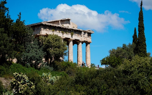 Ancient Agora in Athens with Temple of Hephaestus surrounded by greenery.