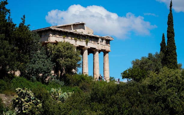 Ancient Agora in Athens with Temple of Hephaestus surrounded by greenery.