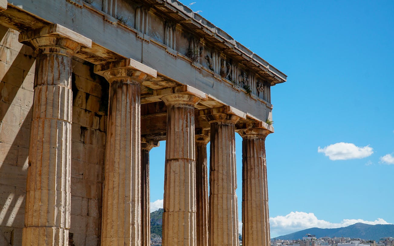 Ancient Agora columns under blue sky in Athens, Greece.