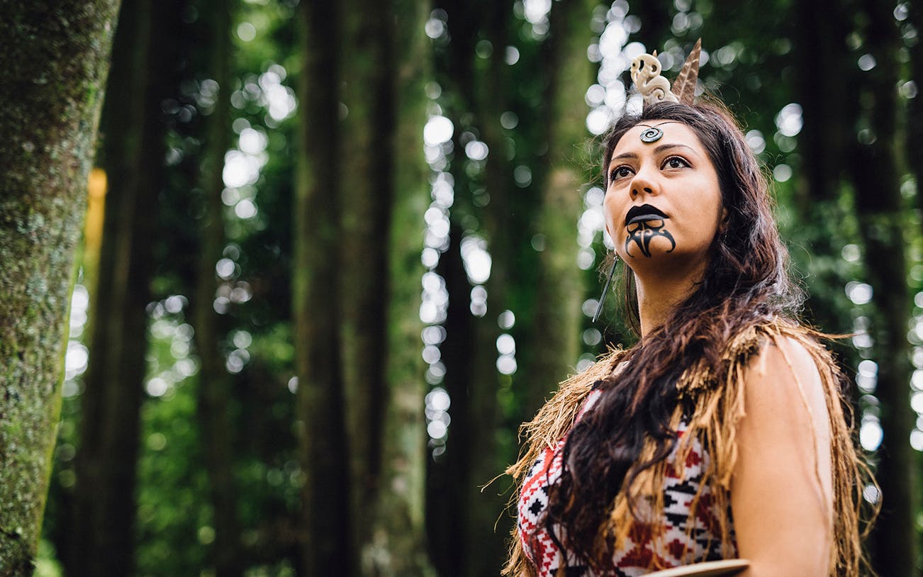 Maori woman in traditional attire at Tamaki Maori Village, New Zealand.