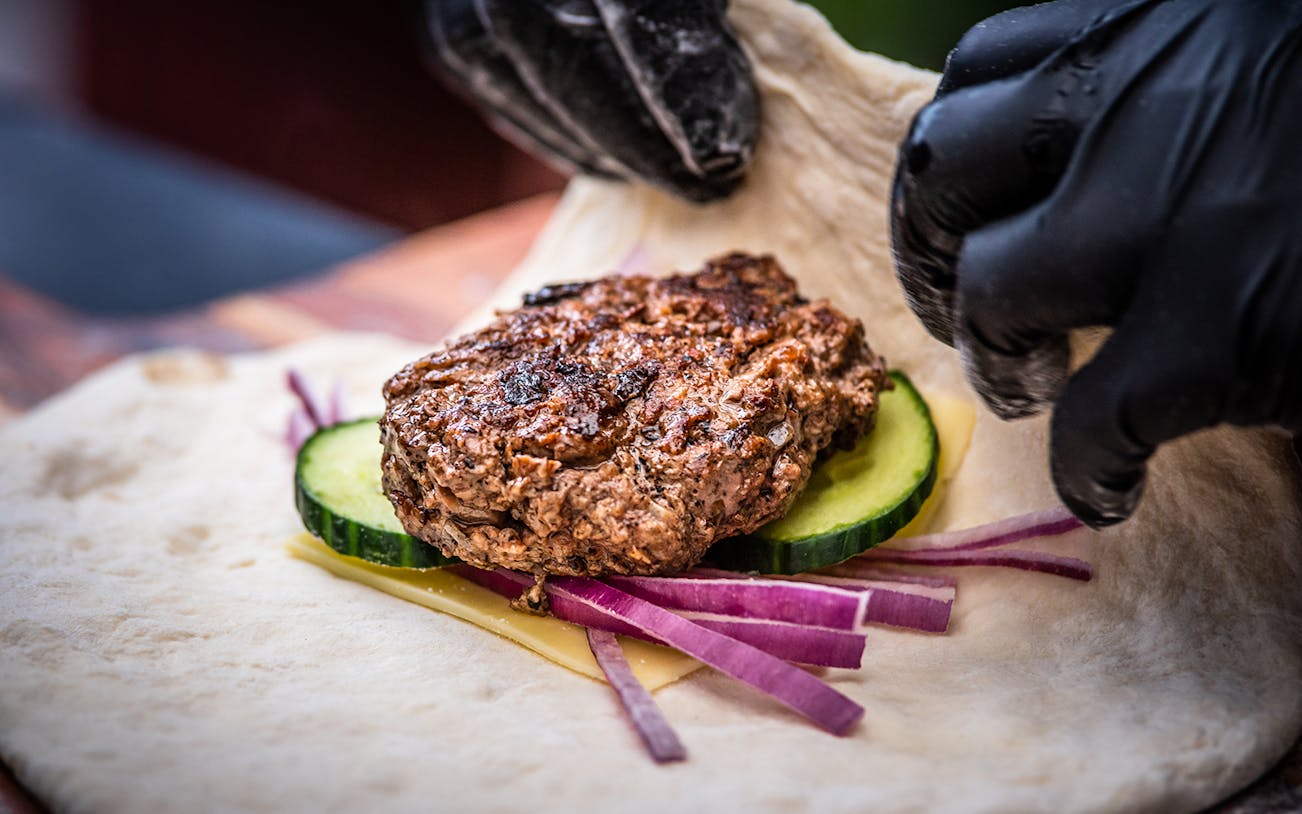 Grilled meat with cucumber and onion on flatbread at Tamaki Maori Village.
