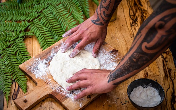 Preparing dough on a wooden board at Tamaki Maori Village, New Zealand.