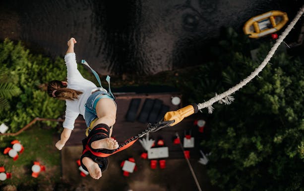 Person bungy jumping over lush greenery in Cairns, Australia.