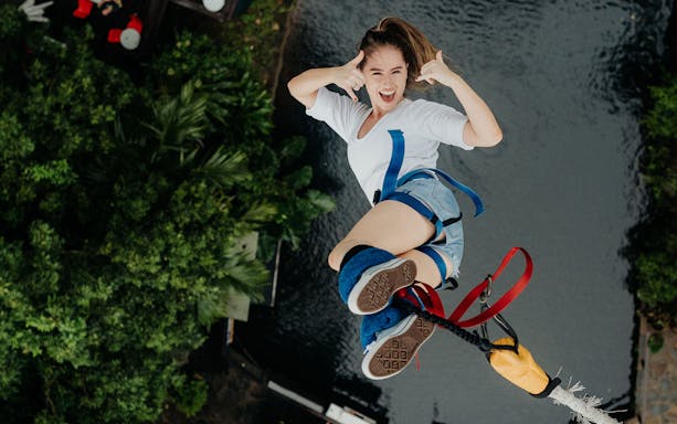 Person bungy jumping over lush greenery in Cairns, Australia.