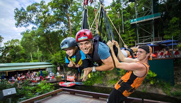 Father and child on giant swing at Cairns adventure park, Australia.