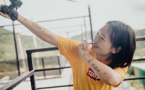 Person at Skypark Cairns with "I can!" written on arms, preparing for adventure.