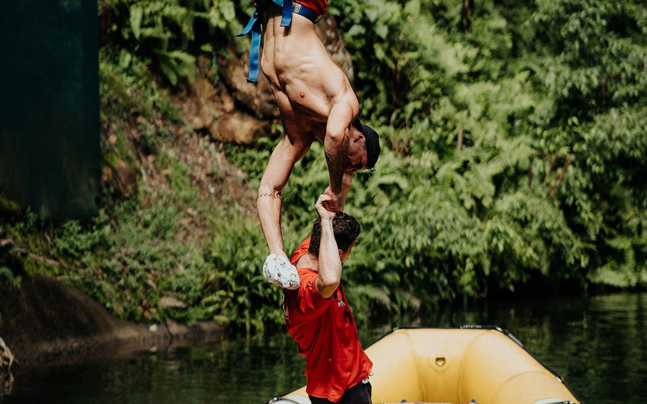 Bungee jumper being assisted over a river at Skypark Cairns Adventure.