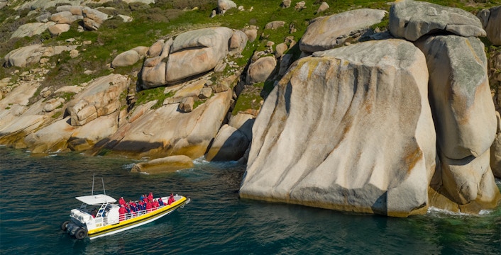 Boat tour near rocky cliffs at Wilsons Promontory, Australia.