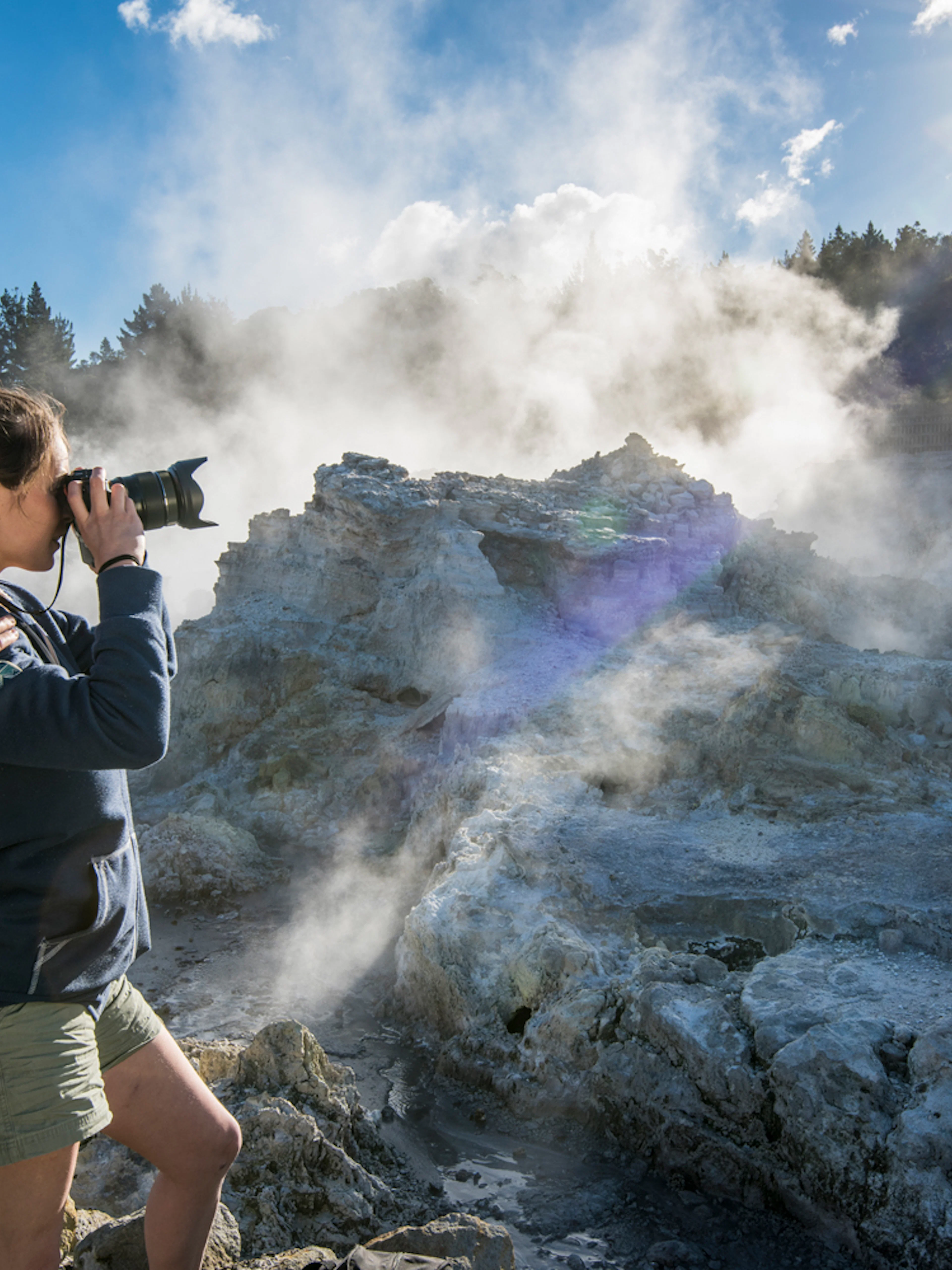 Visitors photographing geothermal steam at Hell's Gate, New Zealand.