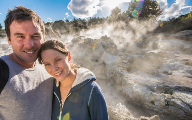 Couple enjoying geothermal steam at Hell's Gate Thermal Experience, New Zealand.