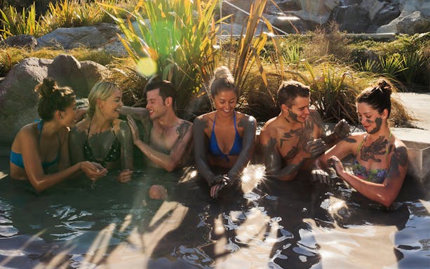 Group enjoying mud bath at Hell's Gate Spa, surrounded by natural scenery.
