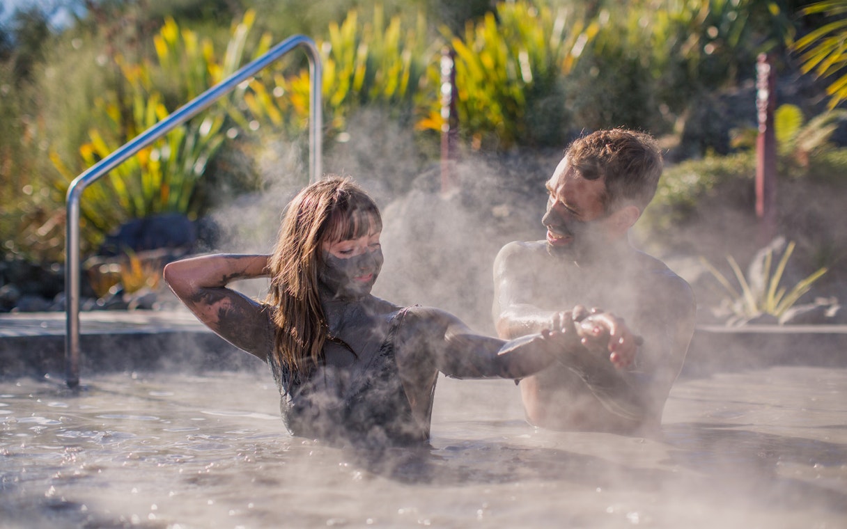 Couple enjoying a mud bath at Hell's Gate geothermal spa.