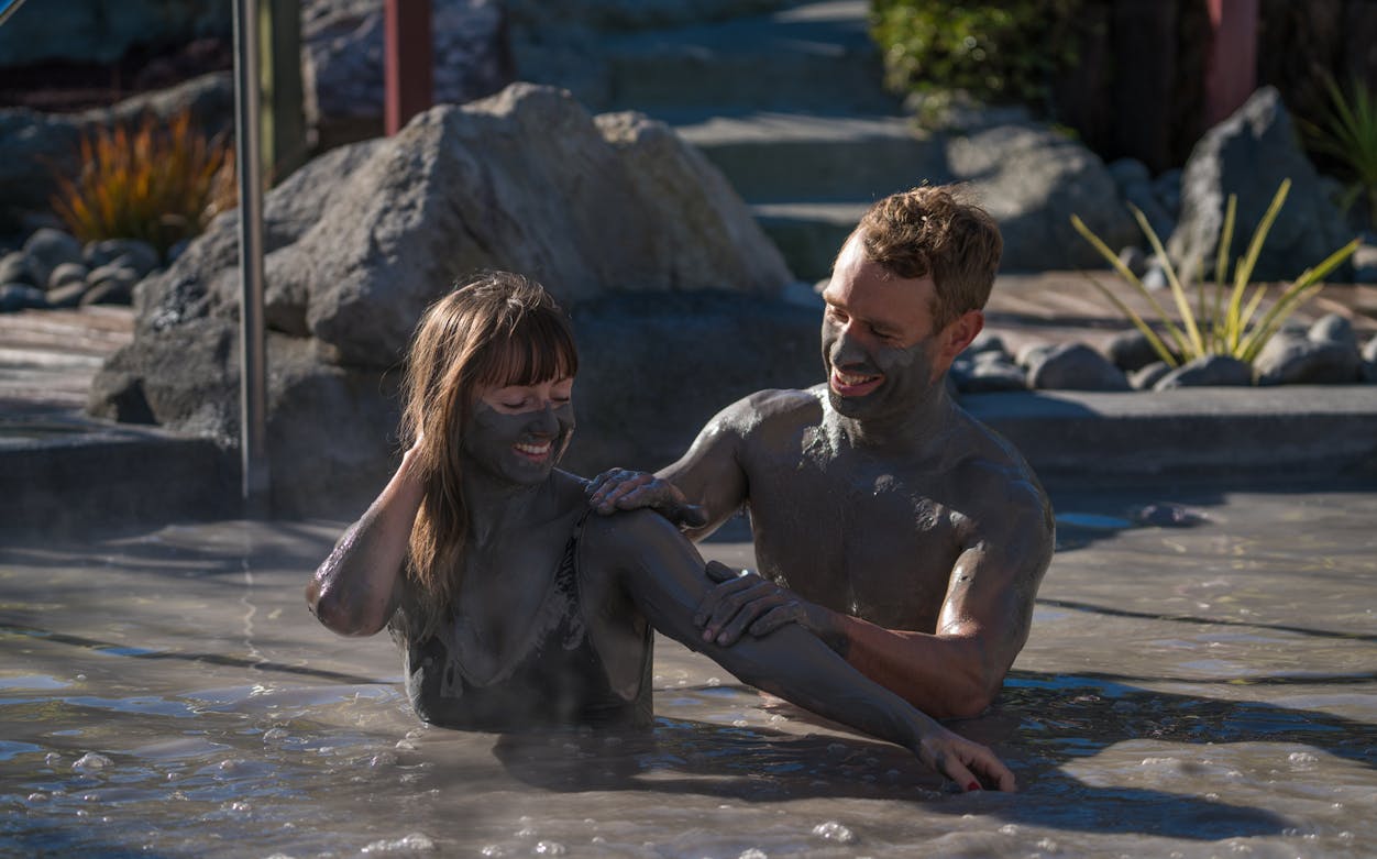 Couple enjoying mud bath at Hell's Gate Sulphur Spas, New Zealand.