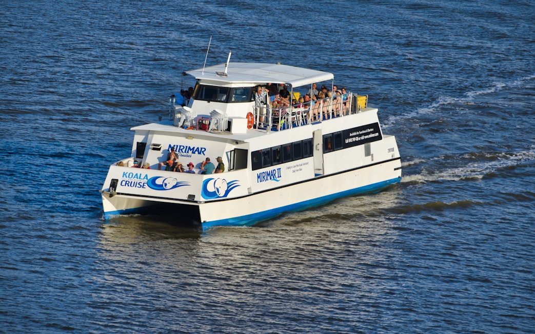 Brisbane River cruise boat heading to Lone Pine Koala Sanctuary with passengers on board.